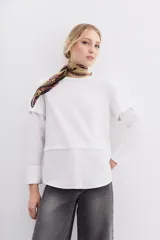Remera blanca de algodón con mangas largas y calce recto. Diseño de doble capa, con remera de mangas rebatidas y camisa clásica debajo.