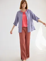 Chaqueta de lino color lila, de corte holgado, escote redondo y mangas 3/4 ajustables con botón.
