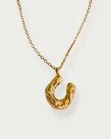 Collar dorado con dije de herradura con diseño calado.