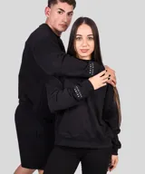 Buzo color beige con cuello alto, confeccionado en 60% algodón y 40% poliéster. Presenta bordado en la manga y no tiene felpa.