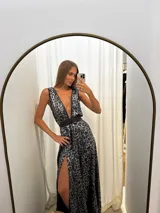 Vestido largo de seda con estampado animal print tornasolado en tonos azul y plateado. Presenta escote pronunciado en V, tirantes anchos y un cinturón ancho de eco cuero negro que marca la cintura. La falda es amplia y tiene una abertura lateral alta.