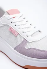 Zapatillas acordonadas blancas con recortes en colores y texturas variadas.