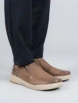 Zapato slip on de cuero color marrón, con elásticos laterales y suela de goma con tecnología Duo-Balance.