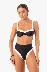 Traje de baño de dos piezas, marca Silvia Schaefer. Top negro con breteles anchos y contorno blanco. Bombacha negra de tiro alto con laterales blancos.