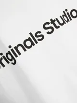 Camiseta blanca de manga corta y cuello redondo con estampado 'Originals Studio' en el pecho.