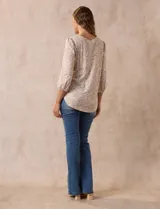 Blusa estampada color beige con cuello redondo calado y mangas 3/4 abullonadas con terminación elastizada.