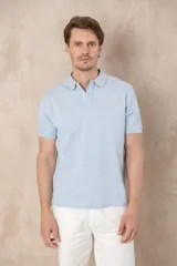 Chomba azul marino de piqué con cuello clásico, tapeta de dos botones y logo de pájaro bordado en color rosa en el pecho.