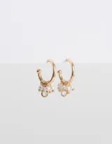 Aros tipo argolla dorados con apliques de perlas blancas y cristal transparente.