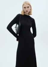 Vestido midi negro de tejido de punto fino en canalé, con cuello alto y manga larga. Diseño evasé sin cierre.