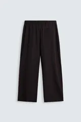 Pantalón marrón oscuro de corte amplio, confeccionado en mezcla de algodón y lino. Presenta cintura elástica, bolsillos laterales y trasero de parche, pliegues frontales, cierre con cremallera y botón.