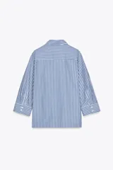 Camisa de mujer con cuello solapa y manga tres cuartos con estampado a rayas verticales verdes y blancas. Cierre frontal con botones ocultos.