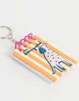 Llavero con forma de libreta con espiral, diseño de perro con manchas en relieve y fondo a rayas verticales.