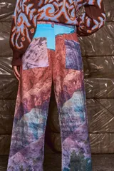 Pantalón de pana sublimado con estampado de montañas y cielo celeste. Tiro medio, corte evasé similar a un oxford, con doble botón y cierre.