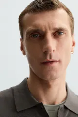 Polo azul marino de punto ligero tejido en hilatura con mezcla de seda y algodón. Cuello solapa con cierre frontal de botonadura, manga larga y acabados en rib.