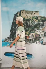 Vestido largo de tejido calado con rayas horizontales en color crudo, azul marino y rojo. Tiene tajo lateral y logo bordado en la manga.