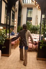 Blazer oversize con diseño asimétrico, mitad en tela a cuadros gris y blanco, mitad en tela lisa gris. Tiene solapas, cierre con botones y pin de salchicha decorativo.