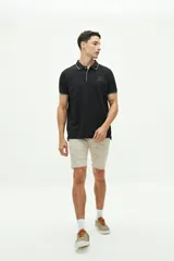 Polo de piqué negro con cuello clásico, tapeta de dos botones y logo bordado en el pecho. Presenta ribete celeste en cuello y mangas. Corte regular.