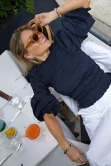 Top azul marino con punto smock, mangas abullonadas y escote redondo.
