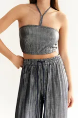 Top bandeau plateado con textura plisada y cuello halter fino.
