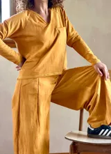 Conjunto de buzo liviano con cuello en V y bolsillo en el pecho, y pantalón palazzo evasé color mostaza batik.