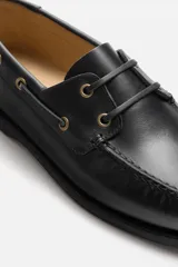 Zapato náutico de cuero negro con cordones de cuero y suela plana.