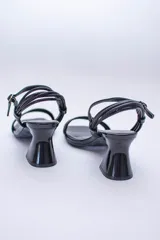 Sandalias de tiras finas color lila metalizado, con taco geométrico plateado.