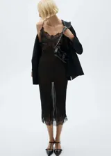 Blazer negro con solapas satinadas, forro interior, cierre frontal con botón, dos bolsillos de ribete y mangas largas abotonadas.