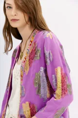 Kimono de viscosa con jacquard en lurex multicolor, bordado de hilo y piedras en cuello y cartera. Largo a la cadera, con ruedo redondeado y forrería en viscosa a tono.