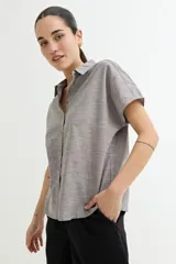 Camisa gris sin mangas de lino con cuello clásico y cierre frontal con botones.