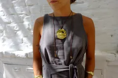 Collar con dije grande de bronce con forma de ostra y cordón de algodón ajustable color gris.