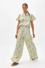Pantalón de lino con estampado floral en tonos amarillos y azules, de corte palazzo y tiro alto.