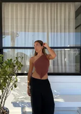 Top tejido con hilo de lurex plateado, corte asimétrico y espalda descubierta.