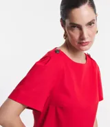 Vestido corto rojo de lino, con cuello redondo, mangas cortas abullonadas y detalle de botones en los hombros.