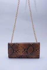 Cartera tipo sobre color beige con textura granulada y correa de cadena dorada.