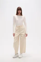 Pantalón cargo de jean color beige, de calce bajo, con bolsillos laterales y cordón ajustable en la cintura.