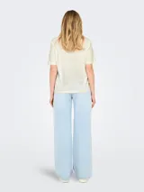 Remera color crema de algodón con estampado de un jinete en un caballo en el desierto.