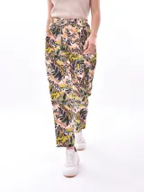 Pantalón babucha de tela estampada con hojas en tonos rosa, naranja y azul, con cintura elastizada y lazo para ajustar.