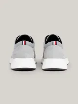 Zapatillas de corte medio color gris claro, con exterior de ante, interior de poliéster reciclado, plantilla extraíble de poliuretano y poliuretano reciclado, suela de goma y caucho, trabilla para calzar distintiva y logo de Tommy Hilfiger en bajo relieve en el lateral y la parte trasera.