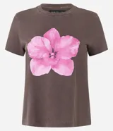 Remera manga corta color marrón con estampa de flor rosa en el frente. Confeccionada en algodón BCI más sostenible.