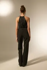 Pantalón de jean negro de corte ancho y tiro alto, con diseño de strass plateado distribuido por toda la prenda.