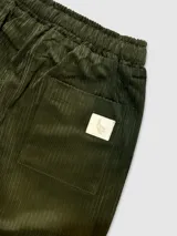 Pantalón de pana verde militar con cintura elastizada, cordón de algodón, bolsillos laterales y un bolsillo trasero.