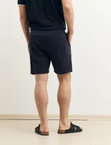 Bermuda de gabardina color gris oscuro, corte recto y largo a la rodilla.