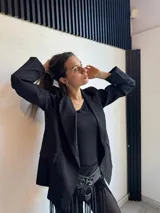 Blazer negro de corte recto, con solapas de muesca y cierre cruzado con doble botón.