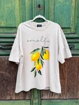 Remerón color beige de corte oversize con estampado de limones y la palabra "Amalfi" en cursiva.