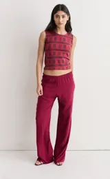 Pantalón de fibrana color bordó con estampado abstracto en tonos oscuros. Tiene cintura elástica y corte ancho y fluido.