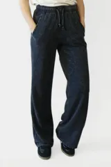 Pantalón negro de corte recto y tiro alto, con cintura elástica y cordón ajustable.