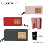 Billetera negra con cierre de cremallera, parche rectangular color beige con el logo de la marca y la inscripción "Free Love". Incluye llavero de tela con el nombre de la marca.