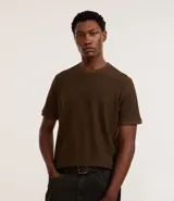 Remera marrón de mangas cortas y cuello redondo, confeccionada en tejido texturizado de algodón y poliéster.
