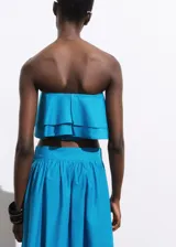 Top strapless celeste con volados y cierre de cremallera en la parte posterior.