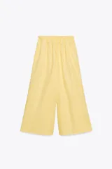 Pantalón culotte amarillo de tiro medio con cintura elástica y bolsillos laterales ocultos en la costura.